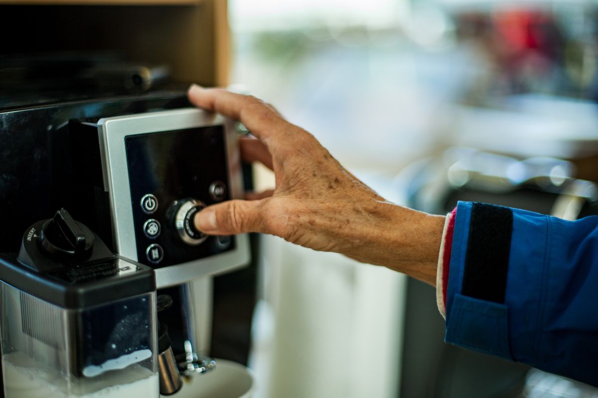 Hand pressing the coffee machine button