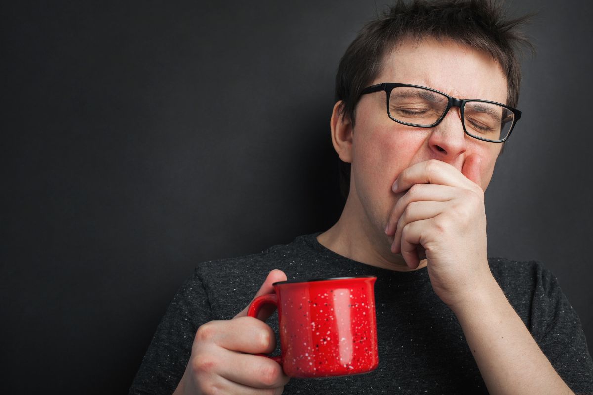 Yawning man drinking coffee